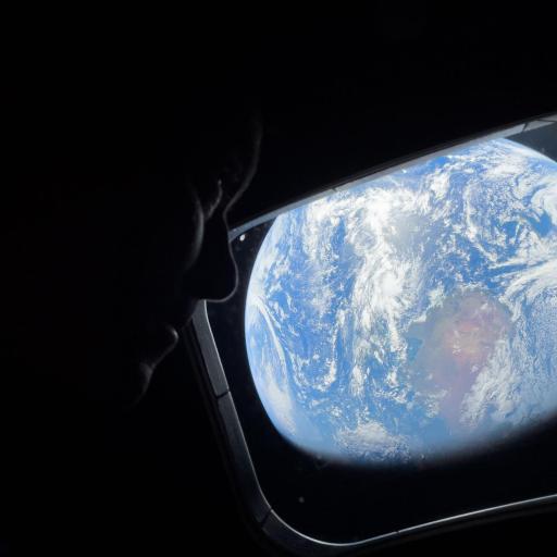 A person’s silhouette looks out a spacecraft window at Earth—a blue and white sphere against the darkness of space—reflecting the hope inspired by Artemis II’s journey to the moon.
