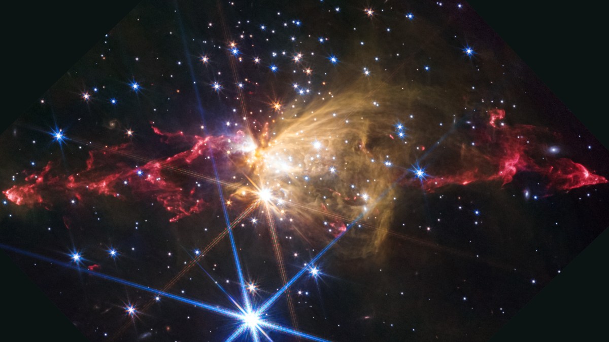 Colorful nebula with bright stars ignite glowing gas clouds in space, featuring red, yellow, and blue hues against a dark background.