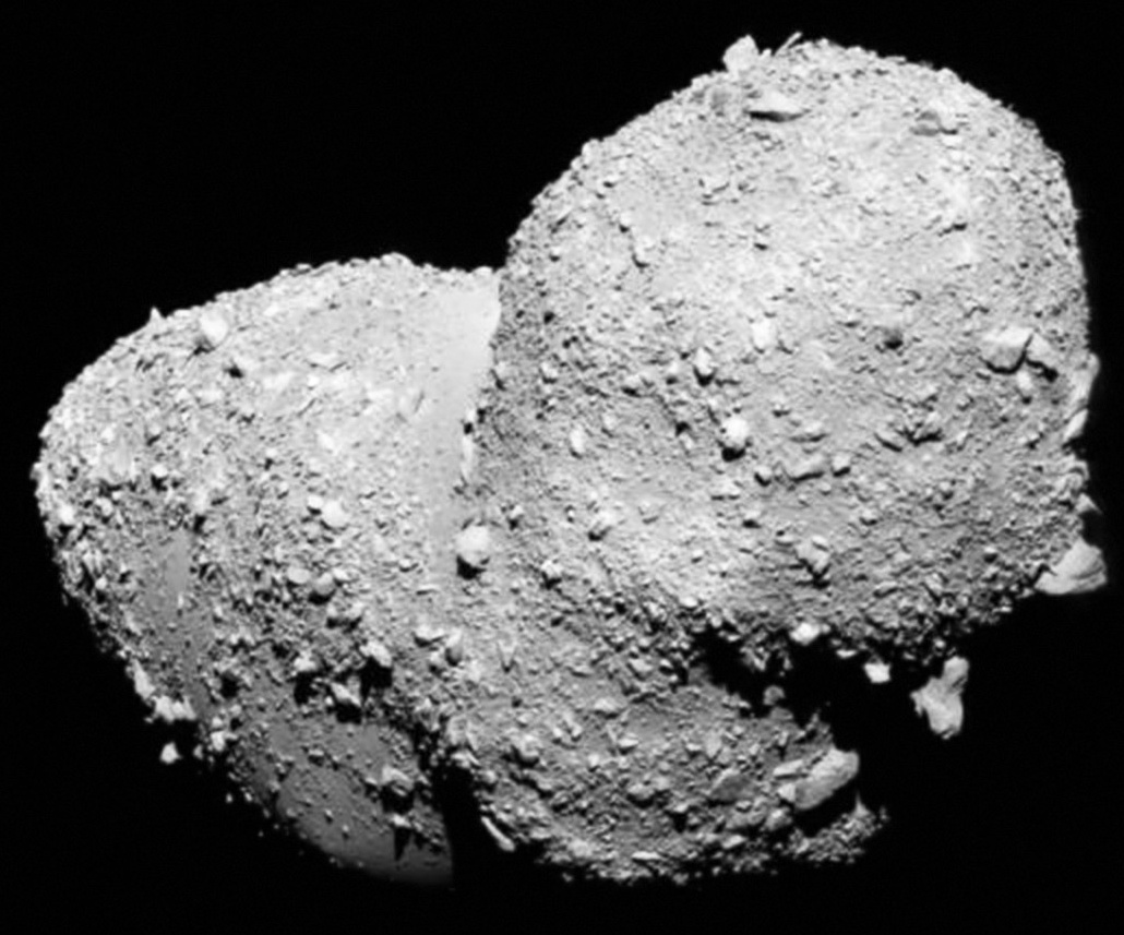 A grayscale image of an irregularly shaped asteroid with a rough, rocky surface set against a black background, illustrating how everything changes when enough mass gathers in the vastness of space.